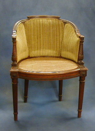 A 19th Century walnutwood carved bergere chair with upholstered seat and back on turned and fluted supports