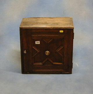 An oak hanging cabinet enclosed by a panelled door 16"