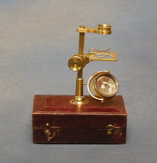 A  19th Century brass student's microscope contained in a leather case with 2 extra lenses, 2 slides and 2 di-dissecting clamps