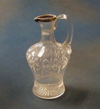 A cut glass claret jug with silver rim 8"