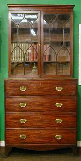 A Georgian mahogany secretaire bookcase, the upper section with moulded cornice, the interior fitted adjustable shelves enclosed by astragal glazed doors, the base fitted a secretaire drawing revealing a well fitted interior above 3 long drawers, raised on splayed bracket feet 40"