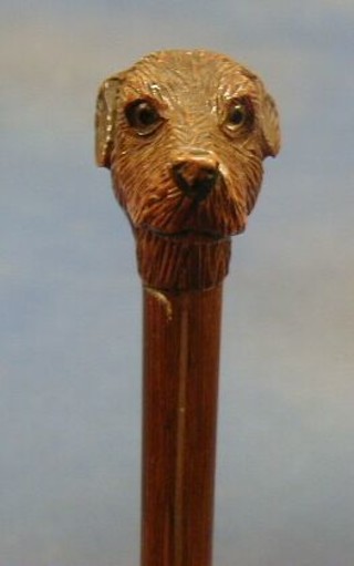 A carved wooden parasol handle in the form of a dogs head