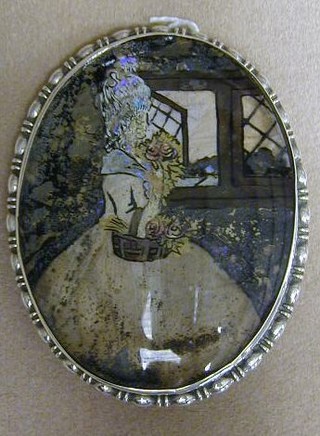 A miniature butterfly wing picture contained in an oval silver frame