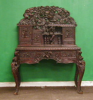 A 19th Century Oriental carved hardwood desk, the raised back carved a dragon, fitted various cupboards, niches and drawers, the base fitted 2 short drawers raised on dragon supports 41"