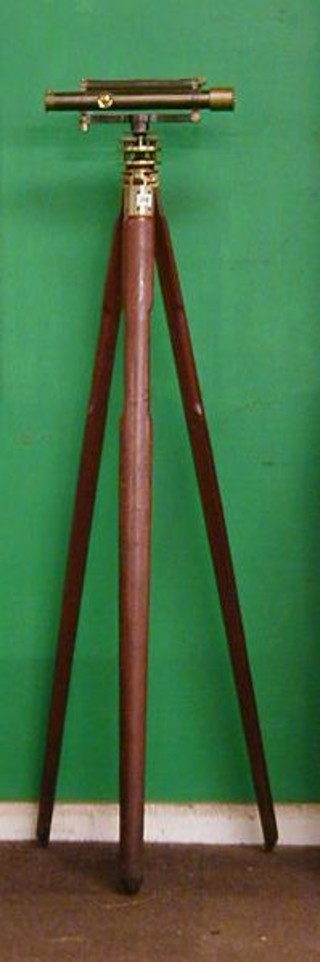 A 19th Century gun metal and brass surveyor's dumpy level by Troughton & Simms of London raised on a mahogany and brass tripod complete with mahogany carrying case
