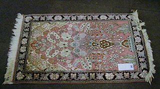 A fine quality Persian silk pink ground rug decorated a vase of flowers within multi borders 35" x 24"