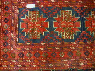 A modern red ground Persian carpet with 3 stylised octagons to the centre within multi row borders 72" x 42"