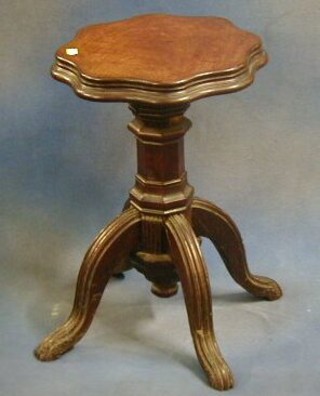 A Victorian mahogany adjustable piano stool, the seat of serpentine outline, on octagonal column and tripod supports