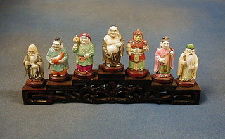 A set of 7 modern Oriental figures raised on a hardwood stand