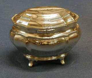 An oval silver caddy with hinged lid, raised on 4 panel supports, London 1929 by the Goldsmiths & Silversmiths Co. 5 ozs