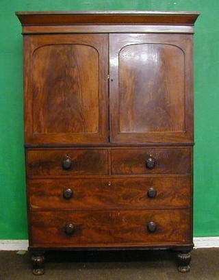 A Victorian mahogany linen press with cornice, the shelved interior enclosed by arched panelled doors, the base fitted 2 short and 2 long drawers, raised on bun supports 46"