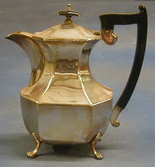 A silver plated hotwater jug of panelled construction