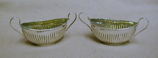 A pair of Edwardian miniature silver twin handled salts with demi-reeded decoration, London 1902