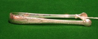 A pair of George III Irish silver sugar tongs with bright cut decoration, the lower inner rim engraved CP and with makers mark JP