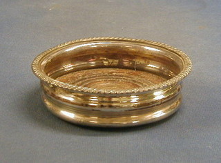 A circular silver plated wine coaster