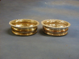 A pair of silver plated wine coasters