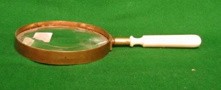 A magnifying glass with turned ivory handle