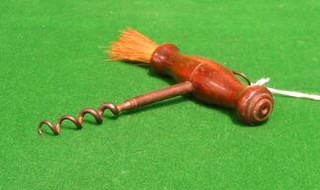 A 19th Century steel cork screw with turned wooden handle and brush