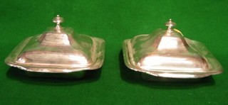 A pair of square twin handled silver plated butter dishes