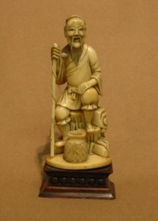 A 19th Century Japanese carved ivory figure of a gentleman with stick and basket 5" on a hardwood stand