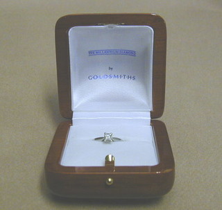 A white gold engagement ring set a square cut diamond "The Millennium Diamond" by Goldsmiths