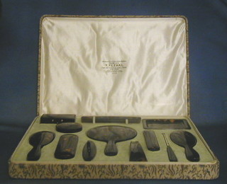 A Japanese 12 piece tortoiseshell dressing table set comprising rectangular trinket box, circular rouge pot, pin tray, comb, handmirror, nail buffer, shoe horn, 2 clothes brushes, 2 hair brushes and a button hook, cased