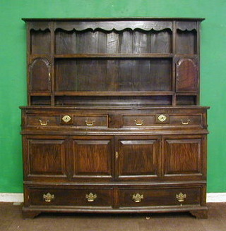 A 17th Century oak dresser  the raised back fitted 2 shelves flanked by a pair of cupboards, the base fitted 2 drawers above a double cupboard, above a further 2 long drawers with brass swan neck drop handles 61"