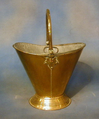 A brass helmet shaped coal scuttle with zinc liner