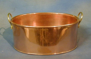 An oval copper planter with brass handles 13"