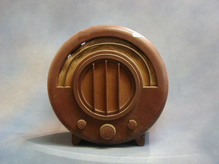 An Ecko electric radio Type AD65 receiver, contained in a round Bakelite case (slight chip to right hand knob and slight distortion to frequency indicator) 16"