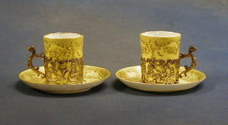 A pair of Staffordshire yellow glazed egg shell porcelain coffee cans, contained in Edwardian pierced silver mounts Birmingham 1900 (cups cracked)