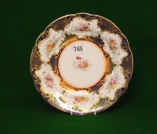 A circular Coalport porcelain plate with floral decoration and blue and gilt banding 9"