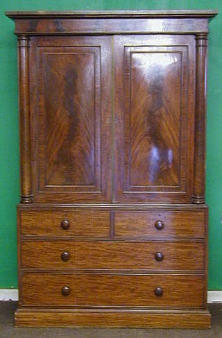 A Victorian mahogany linen press with moulded cornice enclosed by panelled doors, the base fitted 2 short and 2 long drawers, raised on a platform base 48"