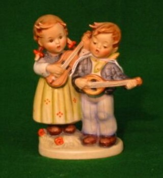 A Hummel figure of a boy with mandolin and girl with guitar, marked 150 4",