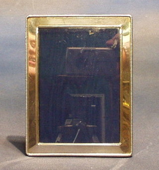 A modern plain silver easel photograph frame with bead work border 6" x 5"