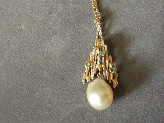 A 14ct barked gold pendant set emeralds and hung a large pearl