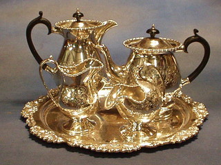 A silver plated 5 piece tea service comprising circular tray with bracketed and cast borders, teapot, hotwater jug, cream jug and sugar scuttle