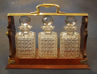 A Victorian oak and silver plated 3 bottle tantalus with 3 cut glass decanters, by the Army & Navy Stores