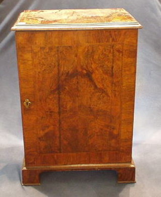A Queen Anne style walnutwood cabinet, the interior fitted a brushing slide and 2 trays, enclosed by a panelled door, raised on bracket feet 26"