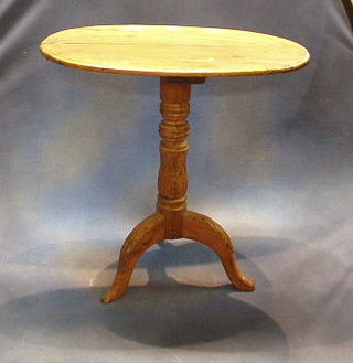 A Continental oval walnutwood wine table raised on a carved column and tripod supports 28"
