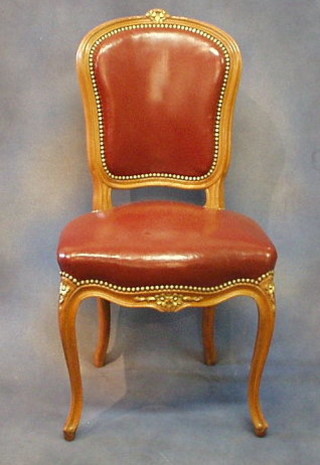 A set of 6 French carved walnutwood dining chairs the seats and backs upholstered in leather, on cabriole supports