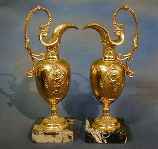A pair of gilt metal ewers raised on marble bases 14"