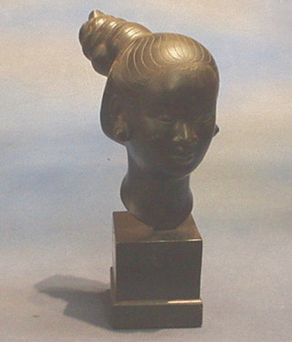 An Eastern bronze head and shoulders portrait bust of a girl, signed, raised on an ebonised base 12"
