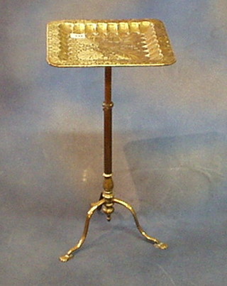 A square benares brass occasional table raised on an adjustable column and tripod support