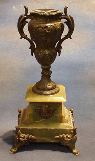 An Art Nouveau spelter twin handled urn raised on a green onyx base