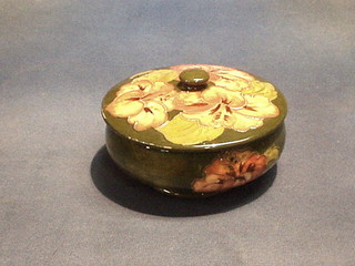 A circular Moorcroft hibiscus patterned jar and cover with green ground (slight rubs to the lid) 6"