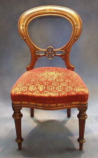 A set of 4 Victorian carved mahogany balloon back dining chairs with pierced mid-rails and upholstered seats on turned and fluted supports