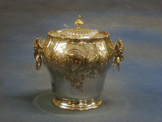 A circular silver plated biscuit barrel with hinged lid and rams mask ring drop handles