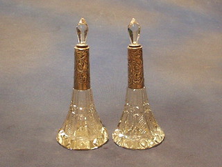 A pair of circular cut glass perfume flasks with embossed silver collars, Birmingham 1911 and 1913 8"