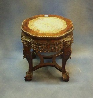 A pierced and carved Oriental Padouk wood jardiniere stand with pink veined marble top, raised on ball and claw supports 17"